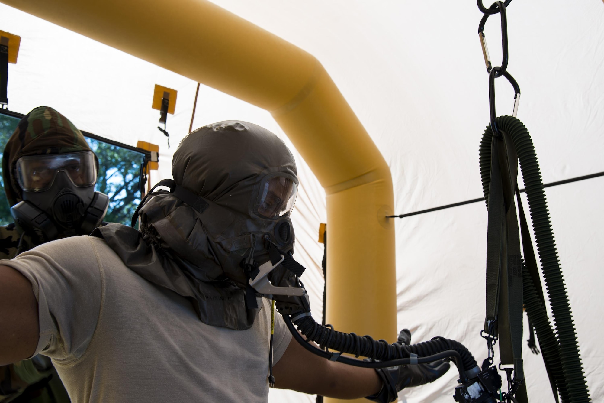 An aircrew flight equipment technician from the 347th Operations Support Squadron, left, removes a mask from Capt. Chisom Ezeoke, 71st Rescue Squadron combat systems officer, during Aircrew Contamination Control Area training, Aug. 24, 2017, at Moody Air Force Base, Ga ACCA training teaches aircrew how to remove and properly handle any contamination on their gear.  (U.S. Air Force photo by Airman 1st Class Erick Requadt)
