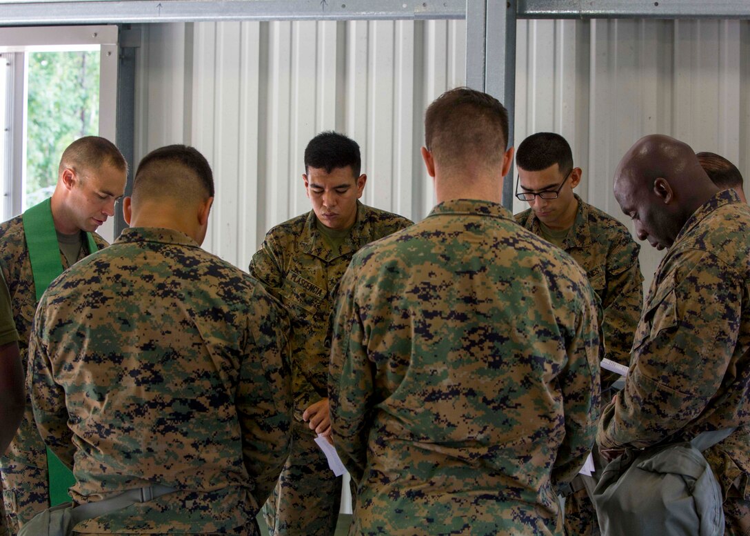 U.S. Navy Lt. Cmdr. John M. Mabus, a chaplain with the 26th Marine Expeditionary Unit (MEU), prays with Marines as part of religious services during Realistic Urban Training (RUT) at Marine Corps Outlying Field Camp Davis, N.C., Aug. 20, 2017.