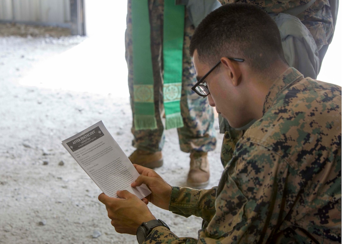 U.S. Marine Corps Sgt. Mitchell Sanchez, a legal service specialist with the 26th Marine Expeditionary Unit (MEU), reads a sermon as part of religious services during Realistic Urban Training at Camp Davis Training Area, N.C., Aug. 20, 2017.