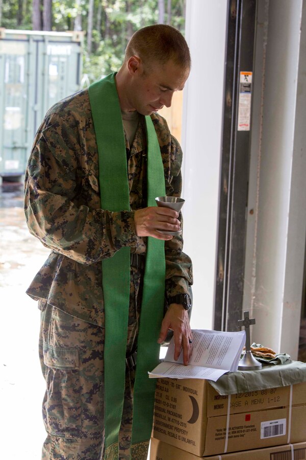 U.S. Navy Lt. Cmdr. John M. Mabus, the 26th Marine Expeditionary Unit (MEU) chaplain, prepares to give communion at a religious service during Realistic Urban Training (RUT) at Camp Davis Training Area, N.C., Aug. 20, 2017. RUT allows the 26th MEU Marines to gain operational experience working as a unit in a simulated forward deployed environment as preparation for an upcoming deployment at sea. (U.S. Marine Corps photo by Sgt. Clemente C. Garcia)