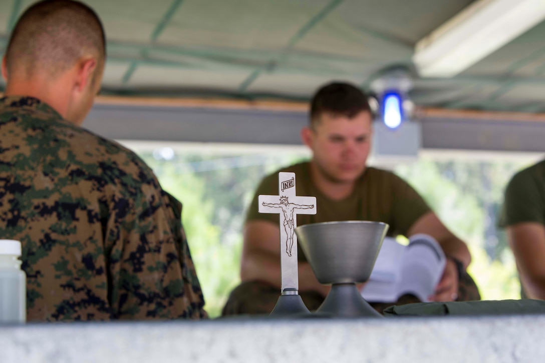 U.S. Navy Lt. Cmdr. John M. Mabus, the 26th Marine Expeditionary Unit (MEU) chaplain, reads a sermon to Marines as part of religious services during Realistic Urban Training (RUT) at Camp Lejeune , N.C., Aug. 20, 2017.