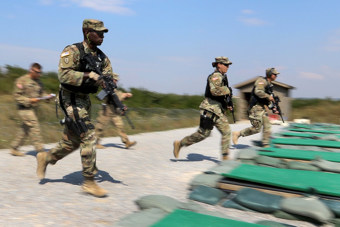 Soldiers sprint to the 25 meter firing line during a Law Enforcement Weapons Training and Qualification range