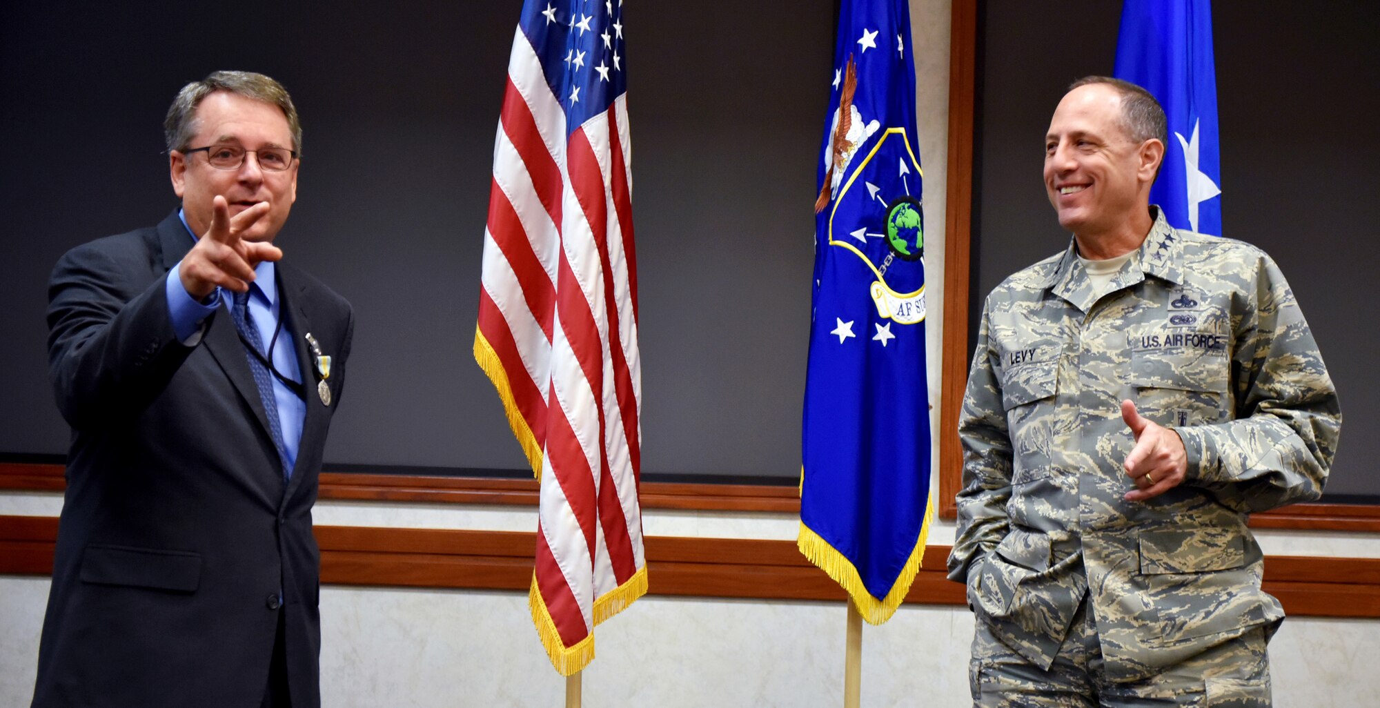 Lt. Gen. Lee K. Levy II, Air Force Sustainment Center commander, and Steven Alsup share a laugh during a farewell ceremony for the AFSC Logistics director on Aug. 25 in the Anaconda Conference Room, Bldg. 3001.