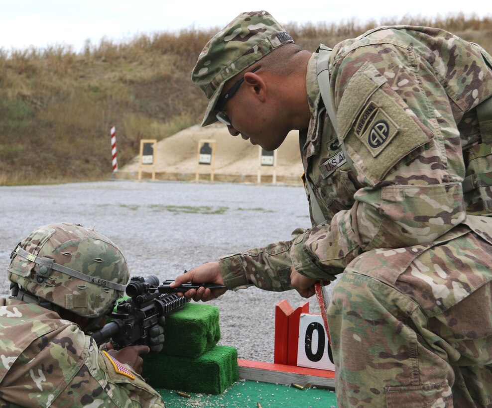 A soldier adjusts an M68 close combat optic scope during the zeroing portion of the M4 qualification range