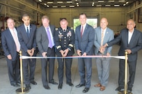 The U.S. Army Reserve’s 99th Regional Support Command hosted a ribbon-cutting ceremony Aug. 17 for the Area Maintenance Support Activity, Organizational Maintenance Shop, on Fort Totten, New York. Major Gen. Troy D. Kok, commanding general of the 99th RSC, center, cut the ribbon at the revitalized facility in Fort Totten. U.S. Congressman Thomas R. Suozzi and New York City Council Member, 19th District, Queens, Paul A. Vallone are third and second from right. The center underwent a $12.6 million full-facility revitalization, allowing technicians to perform in an up-to-date facility to meet readiness standards as well as train military unit mechanics as needed so they can perform maintenance while they’re deployed.