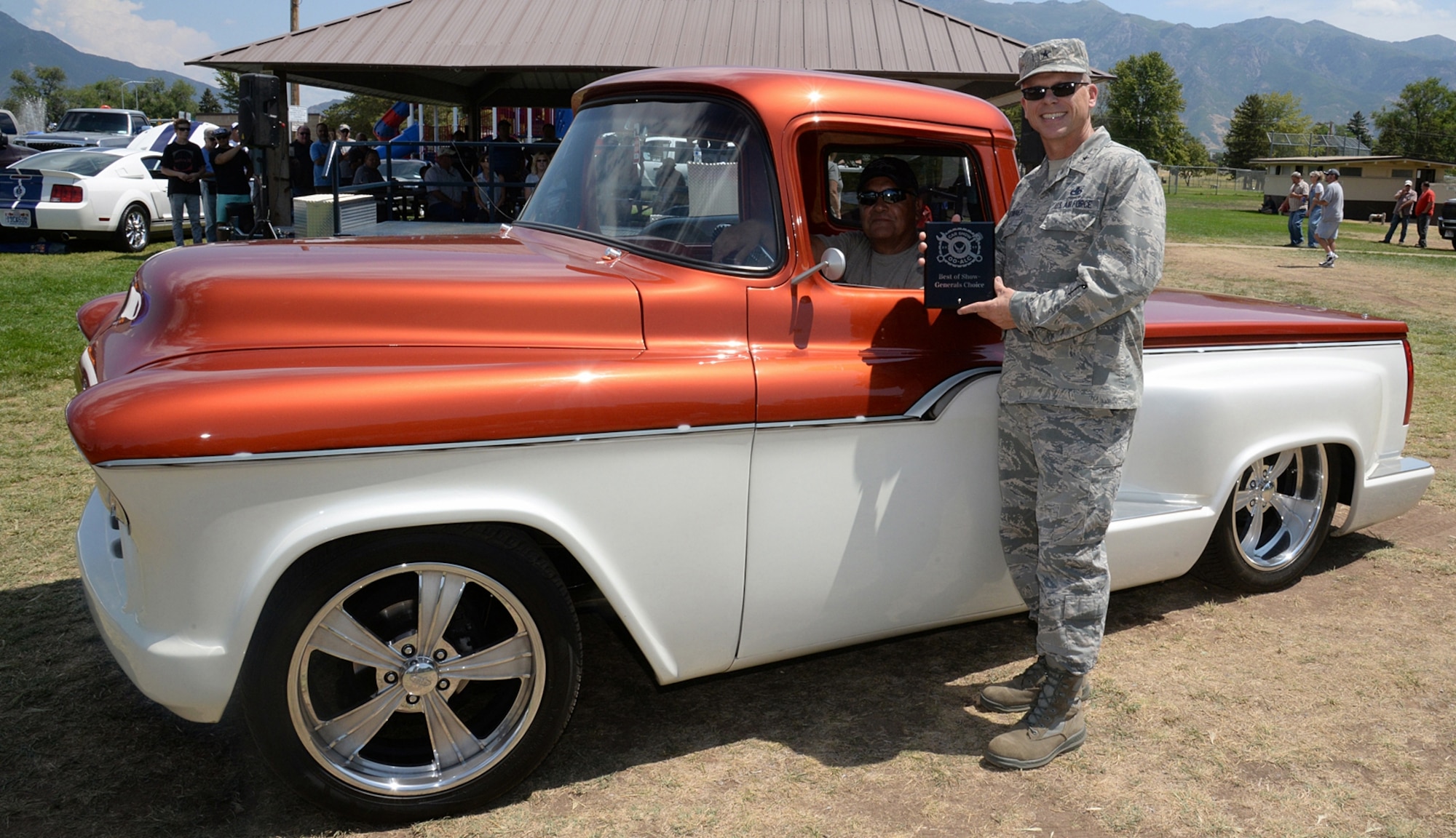 Brig. Gen. Steven J. Bleymaier, Ogden Air Logistics Complex commander, presents the Generals Choice Award to Jake Dominguez, 709th Maintenance Support Squadron electronics mechanic, for his custom pearl white and tangerine, 1955 Chevrolet pickup. (U.S. Air Force photo by Alex R. Lloyd)