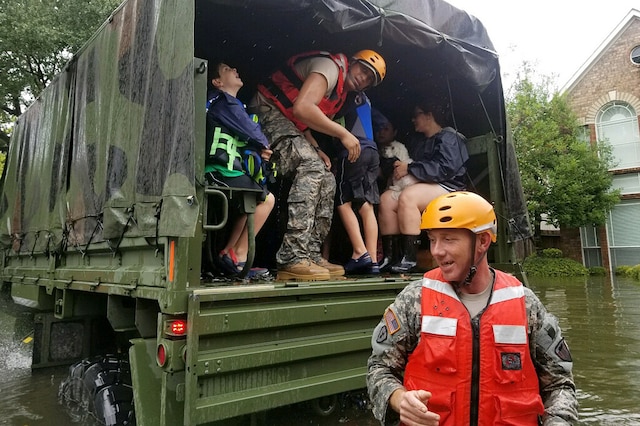 Guardsmen help residents affected by flooding caused by Hurricane Harvey.