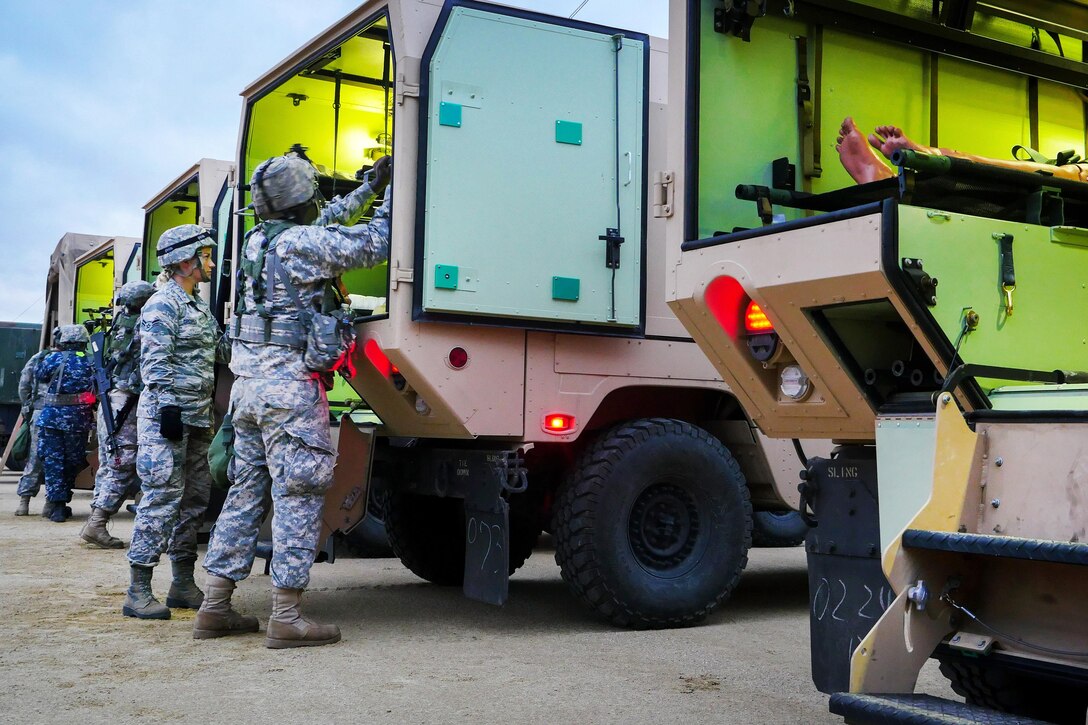 Airmen, sailors and soldiers transport mock casualties of a mass casualty training event during exercise Patriot Warrior