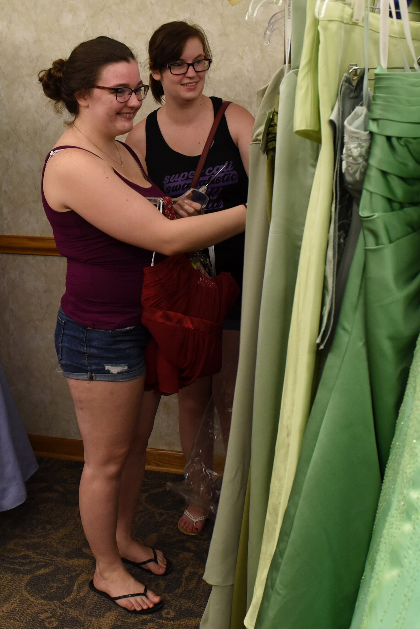 Katie Everett (left), and Cameron Stripling browse through the selection of evening gowns at the Cinderella’s Closet program, Aug. 23, 2017, at Seymour Johnson Air Force Base, North Carolina.
