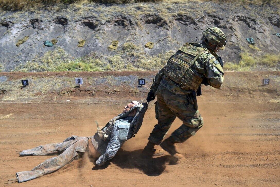A soldier drags a mannequin dressed as a service member.