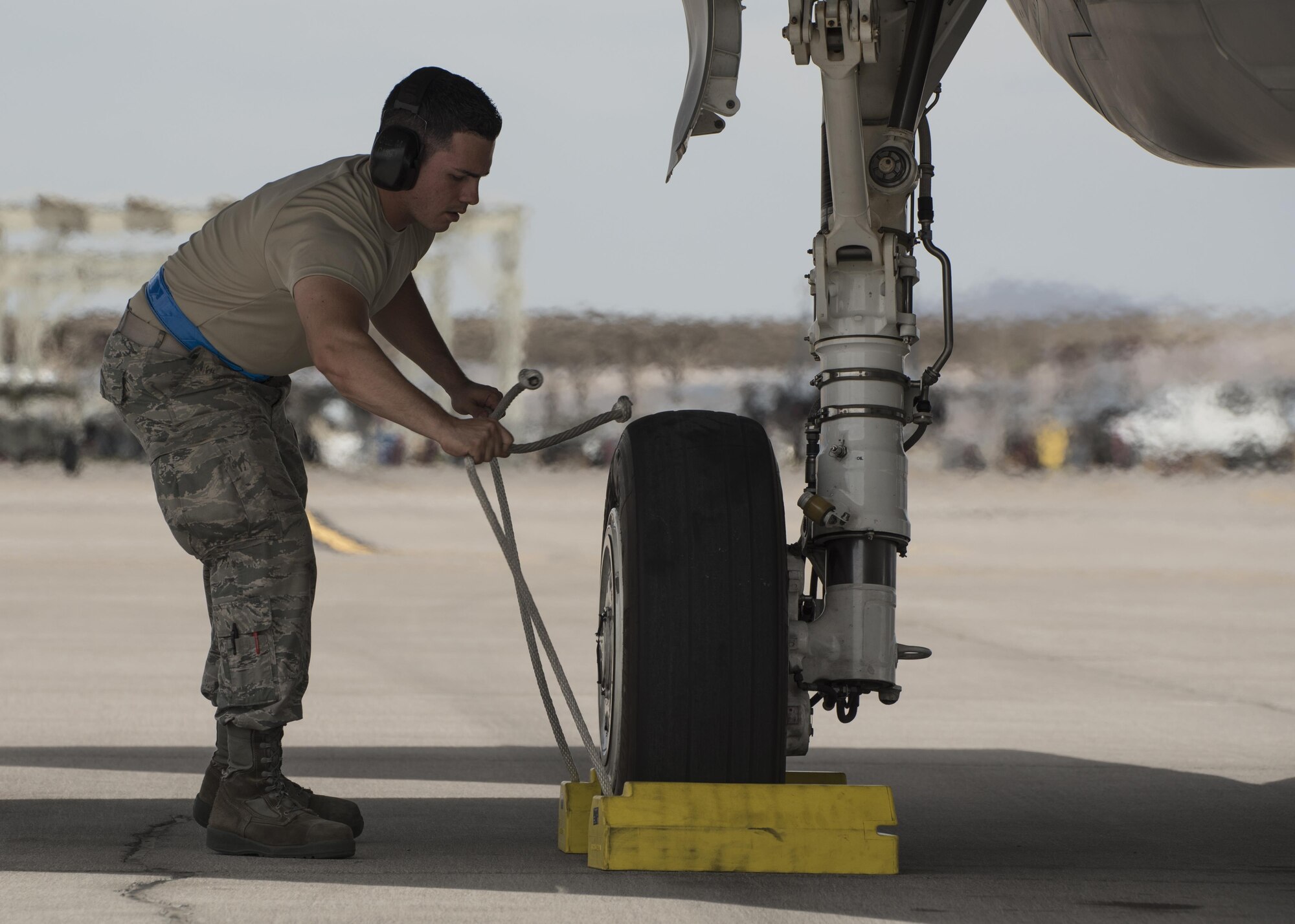 Staff Sgt. Marcos Cruz La Santa, 33rd Aircraft Maintenance Squadron avionics systems technician, pulls chocks from beneath an F-35A Lightning II July 18, 2017, at Nellis Air Force Base, Nev. Cruz is one of the first core F-35 trained maintainers in the Air Force to become a noncommissioned officer. (U.S. Air Force photo by Staff Sgt. Peter Thompson)