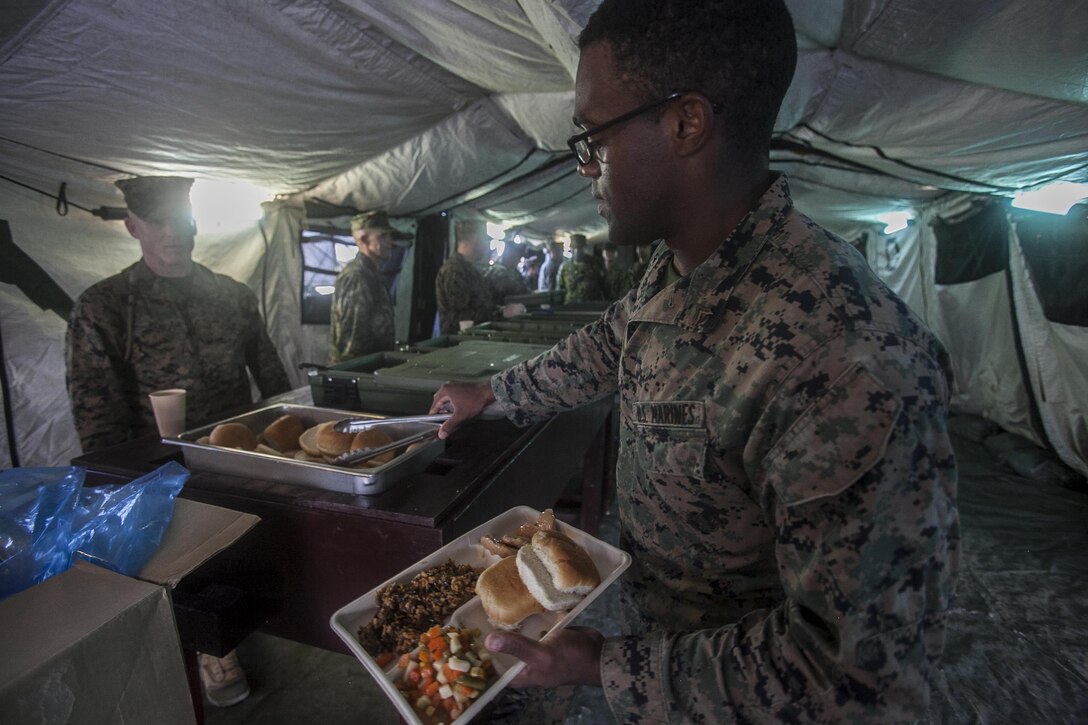 A U.S. Marine with 1st Marine Aircraft Wing, fills his tray during a warrior dinner on Camp Hansen, Okinawa, Japan, August 26, 2017. 1st MAW, based out of Okinawa, Japan, is the U.S. Marine Corps’ sole forward deployed MAW.