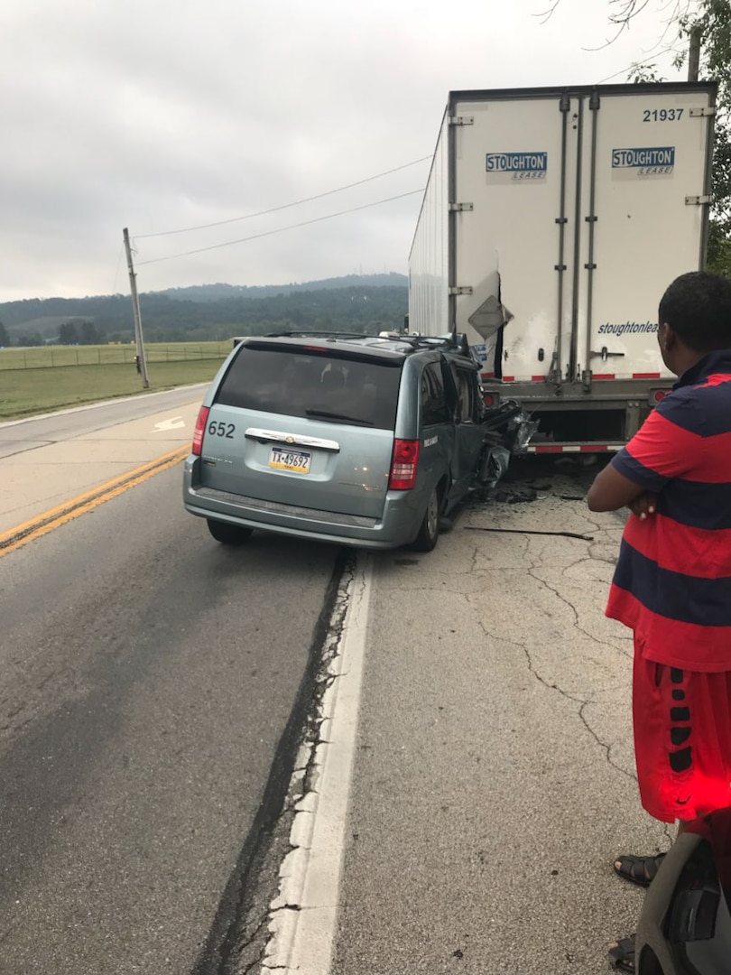 A truck driver looks on moments after an American Taxi minivan crashes into the back of his parked tractor trailer during the early morning hours of Aug. 17, 2017.