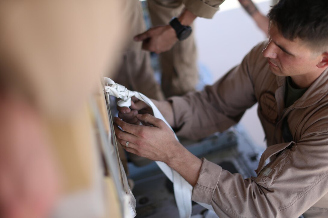 U.S. Marine Staff Sgt. Wesley Martins, a crew master with Marine Aerial Refueler Transport Squadron-352, Special Purpose Marine Air-Ground Task Force — Crisis Response — Central Command, ties down a package onto a KC-130J Super Hercules in preparation for an air delivery exercise. Air delivery is a capability SPMAGTF CR-CC can employ that allows supplies to be delivered to ground troops when they are in remote locations, increasing SPMAGTF-CR-CC’s ability to support itself in austere expeditionary environments.