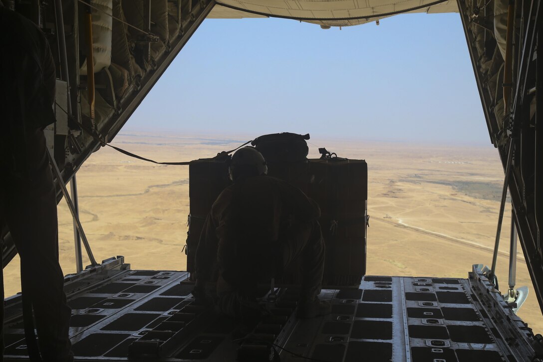 U.S. Marine Gunnery Sgt. Gregory Melson, a crew master with Marine Aerial Refueler Transport Squadron-352, Special Purpose Marine Air-Ground Task Force — Crisis Response — Central Command,  waits for the green light to cut the package free for an air delivery exercise. Air delivery is a capability SPMAGTF CR-CC can employ that allows supplies to be delivered to ground troops when they are in remote locations, increasing SPMAGTF-CR-CC’s ability to support itself in austere expeditionary environments.