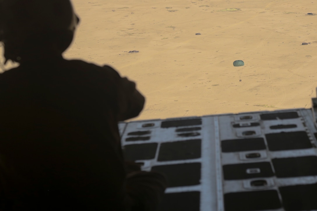 U.S. Marine Gunnery Sgt. Gregory Melson, a crew master with Marine Aerial Refueler Transport Squadron-352, Special Purpose Marine Air-Ground Task Force — Crisis Response — Central Command,  watches the package fall to its target destination during an air delivery exercise. Air delivery is a capability SPMAGTF CR-CC can employ that allows supplies to be delivered to ground troops when they are in remote locations, increasing SPMAGTF-CR-CC’s ability to support itself in austere expeditionary environments.