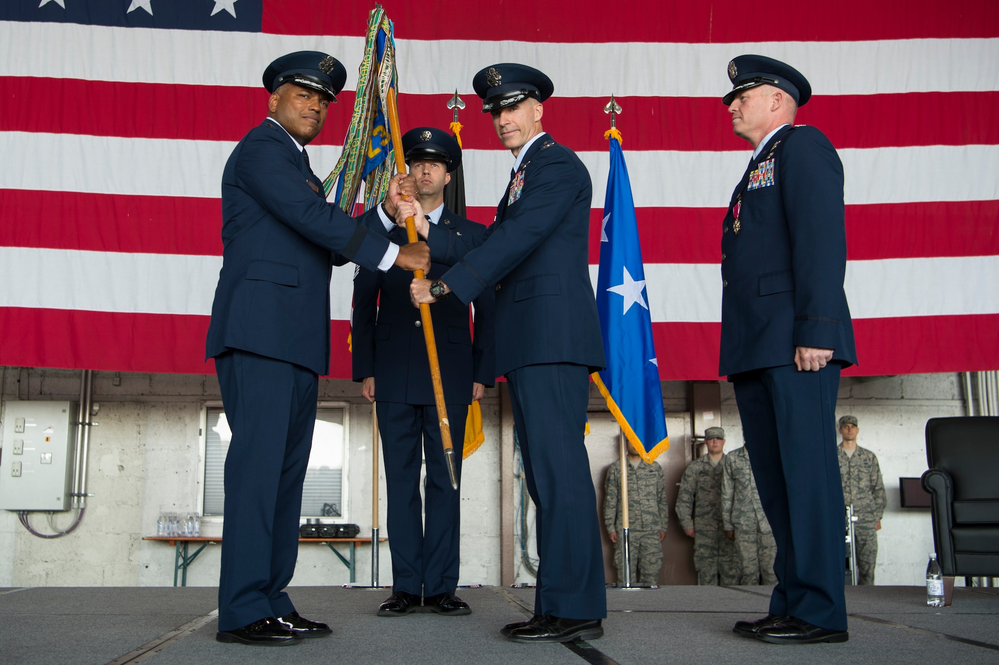 U.S. Air Force Lt. Gen. Richard Clark, 3rd Air Force commander, passes the 52nd Fighter Wing guidon to Col. Jason Bailey, incoming 52nd Fighter Wing commander, during the wing change of command ceremony in Hangar 1 at Spangdahlem Air Base, Germany, Aug. 29, 2017. During the ceremony Col. Joseph McFall relinquished command of the 52nd FW after two and half years as the commander of five groups, 24 squadrons, 11 geographically separated units spread across five countries with 5,000 dedicated military and civilian personnel. (U.S. Air Force photo by Senior Airman Dawn M. Weber)