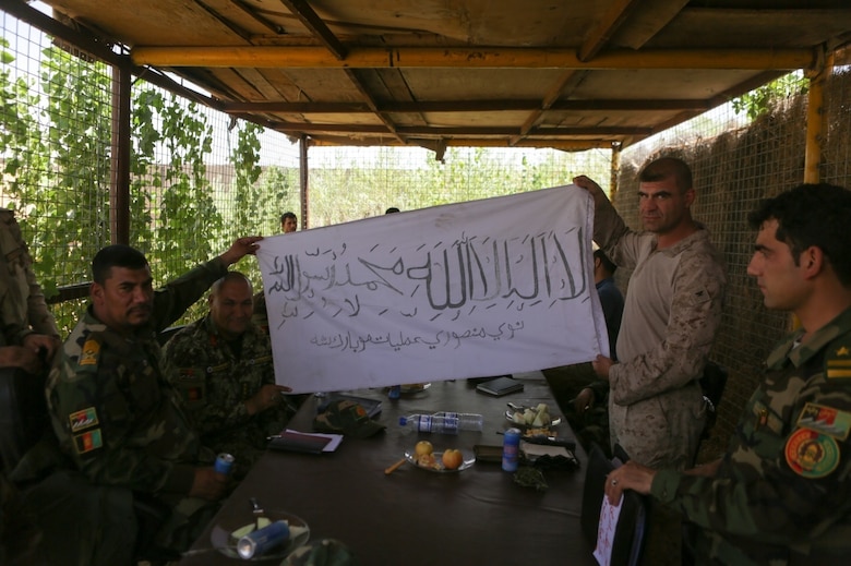 U.S. Marine Col. Matthew Grosz, right, the Task Force Southwest senior advisor to Afghan National Army 215th Corps, displays a captured Taliban flag with 215th Corps soldiers during Operation Maiwand Five near Nawa district of Helmand Province, Afghanistan, Aug. 21, 2017. The flag holds significance as a sign of progress in clearing the Nawa district in Helmand province. Advisors with the Task Force are assisting their Afghan counterparts to deny safe havens to insurgency and promote security and stability to the residents of Nawa. (U.S. Marine Corps photo by Cpl. Tyler Harrison)