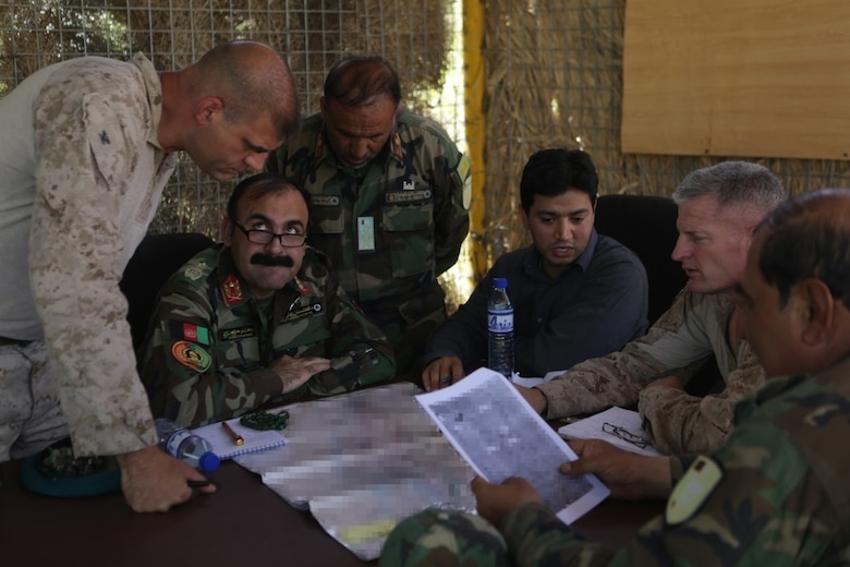 U.S. Marine Col. Mathew Grosz, the Task Force Southwest senior advisor to the Afghan National Army 215th Corps, ANA Maj. Gen. Wali Mohammed Ahmadzai, the commander of 215th Corps, U.S. Marine Brig. Gen. Roger Turner, the commanding general of Task Force Southwest and other Afghan Army soldiers discuss tactics and plans during Operation Maiwand Five near Nawa district in Helmand Province, Afghanistan, Aug. 21, 2017. Advisors with the Task Force are partnering with elements of the Afghan National Defense and Security Forces to clear the Nawa area of insurgency and promote security and stability to the local populace. (U.S. Marine Corps photo by Cpl. Tyler Harrison)