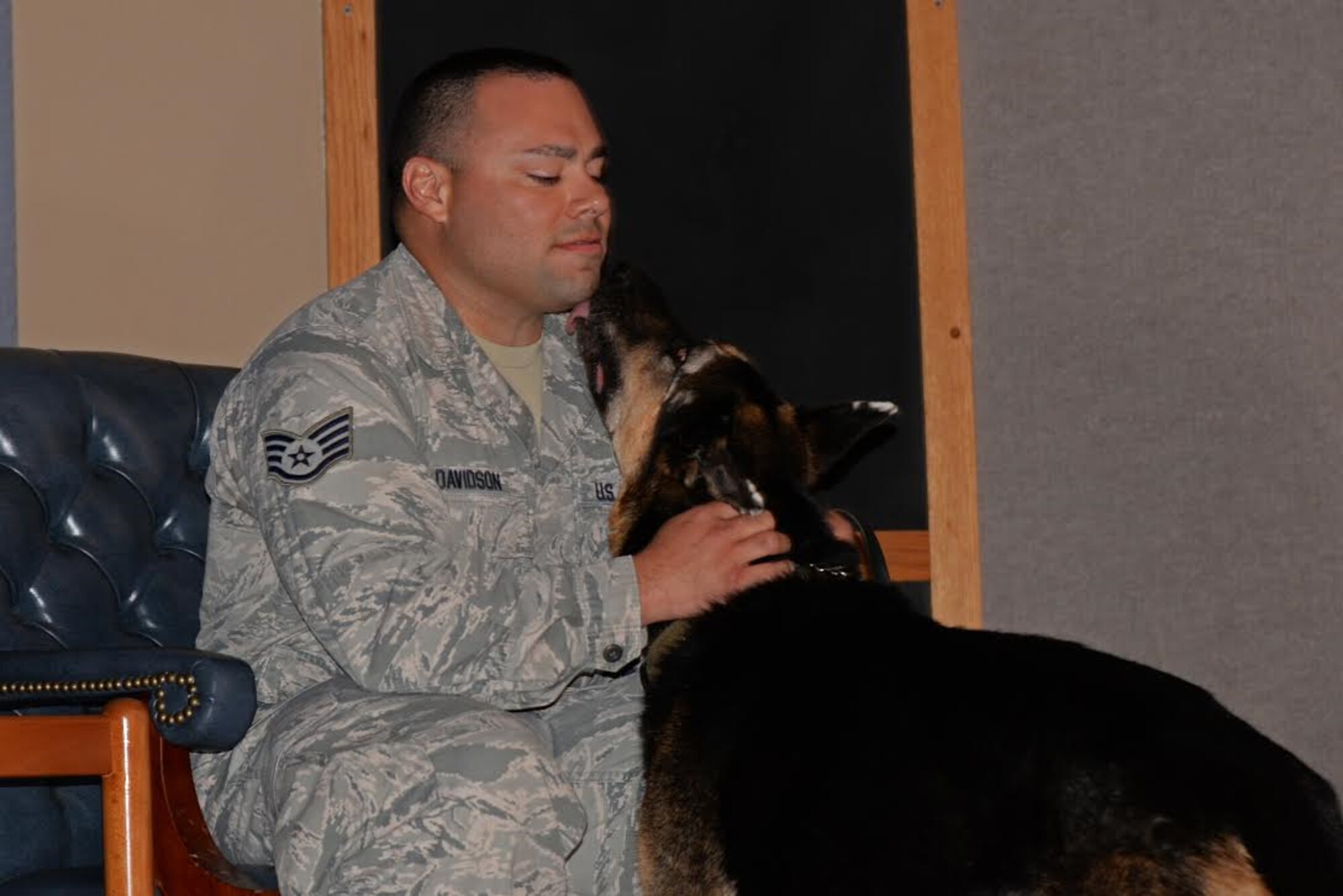 Staff Sgt. Cody Davidson, 47th Military Working Dogs patrolman, sits with his K-9 partner Foxo during Foxo’s retirement ceremony at Laughlin Air Force Base, Texas on August 25, 2017.