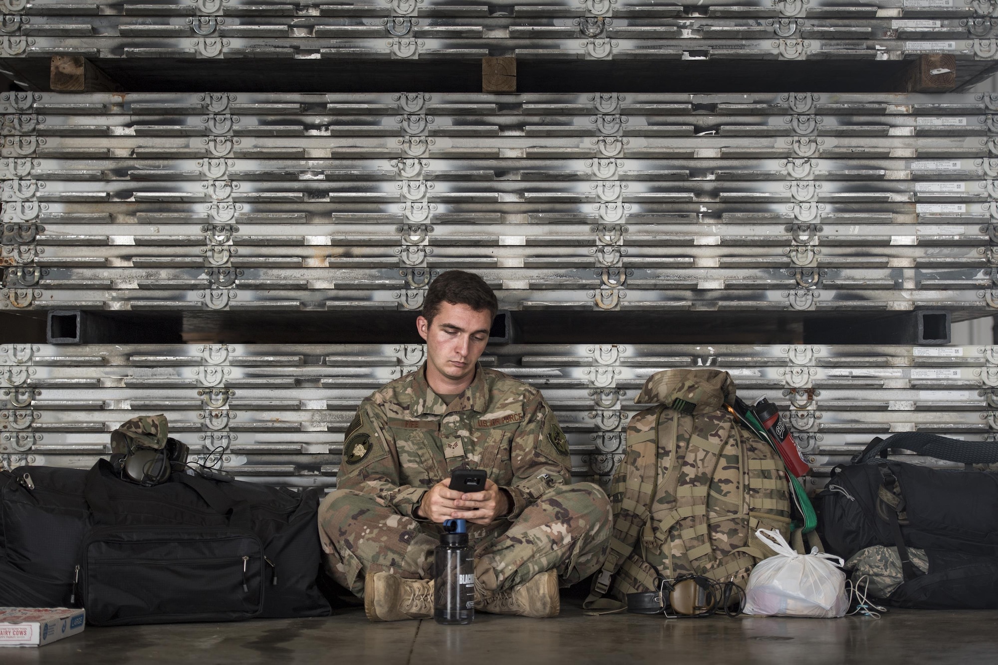 Senior Airman Fife, 723d Aircraft Maintenance Unit, sits against a wall of aircraft pallets in a staging hanger, Aug. 26, 2017, at Naval Air Station Fort Worth Joint Reserve Base, Texas.