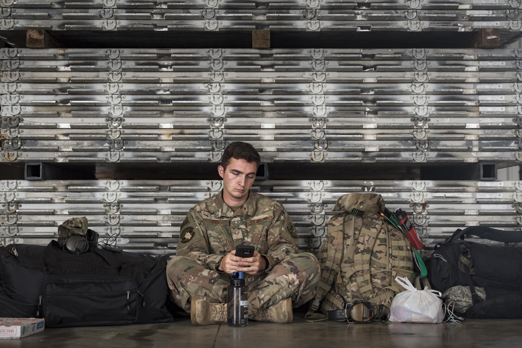 Senior Airman Fife, 723d Aircraft Maintenance Unit, sits against a wall of aircraft pallets in a staging hanger, Aug. 26, 2017, at Naval Air Station Fort Worth Joint Reserve Base, Texas.