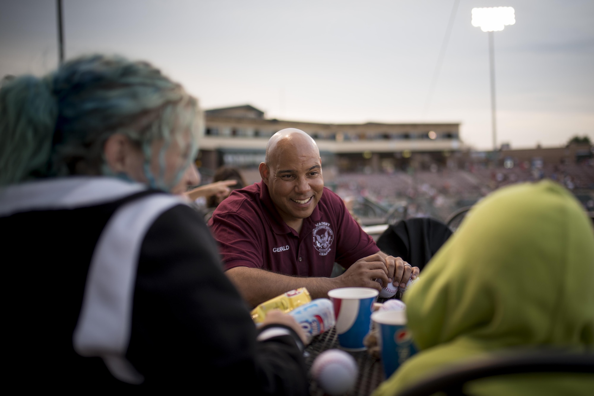 Master Sgt. Gerald Morey, 21st Comptroller Squadron/ Wing Staff Agency first sergeant, laughs with children attending a Snowflake Event at Security Service Field during a Sky Sox baseball game in Colorado Springs, Colo., Aug. 21, 2017. A Snowflake event is regional occurrence hosted for Snowball Express families. Morey and the Non Commissioned Officer Association Air Academy Chapter he belongs to hosted the evening, treating the families to an expense-free night of baseball and bonding. (U.S. Air Force photo by Senior Airman Dennis Hoffman)