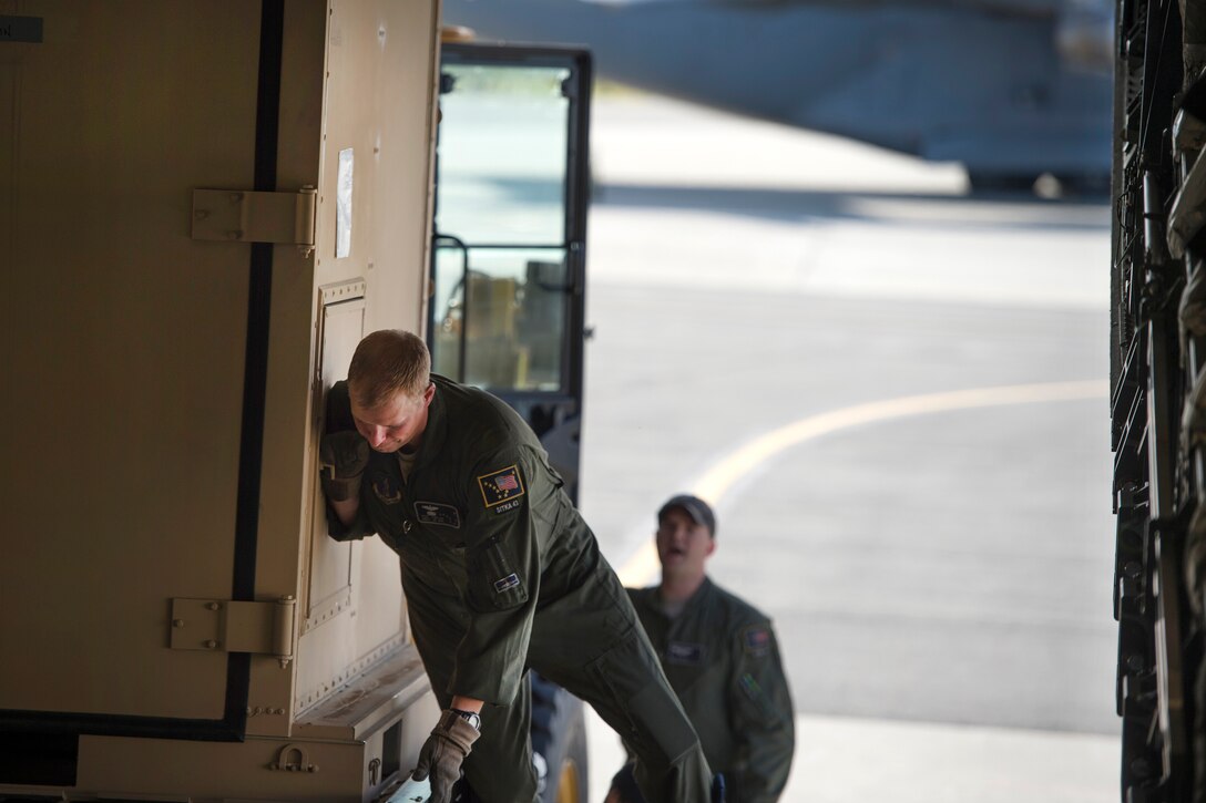 Airmen load and secure cargo into an airplane.