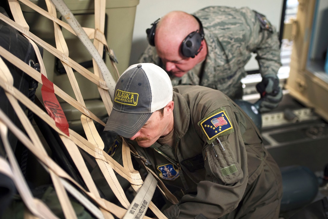 Airmen load and secure cargo onto an airplane.