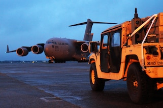 Military equipment sits on a runway.