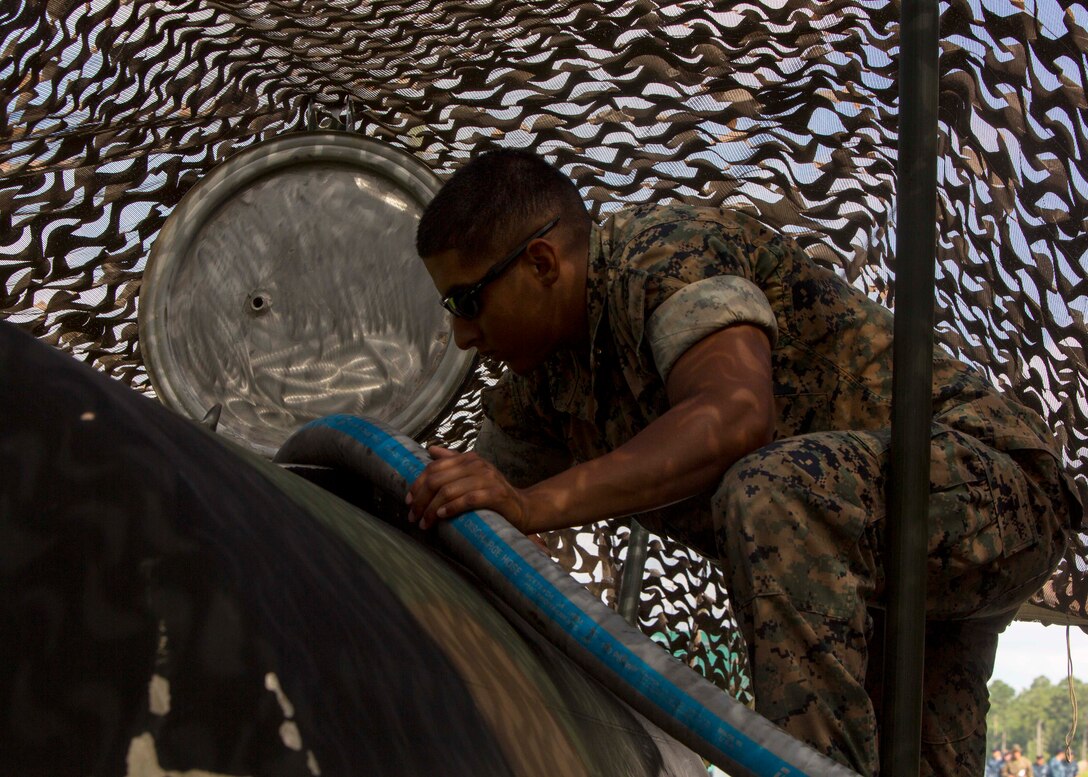 U.S. Marine Corps Lance Cpl. Brandon A. Rojas, a water support technician with Combat Logistics Battalion 26, 26th Marine Expeditionary Unit (26th MEU), refills a water container with potable water during Realistic Urban Training (RUT) at Marine Corps Outlying Field Camp Davis - South, N.C., Aug. 19, 2017. RUT allows the 26th MEU Marines to gain operational experience working as a unit in a simulated forward-deployed environment for preparation for an upcoming deployment at sea. (U.S. Marine Corps photo by Sgt. Clemente C. Garcia)