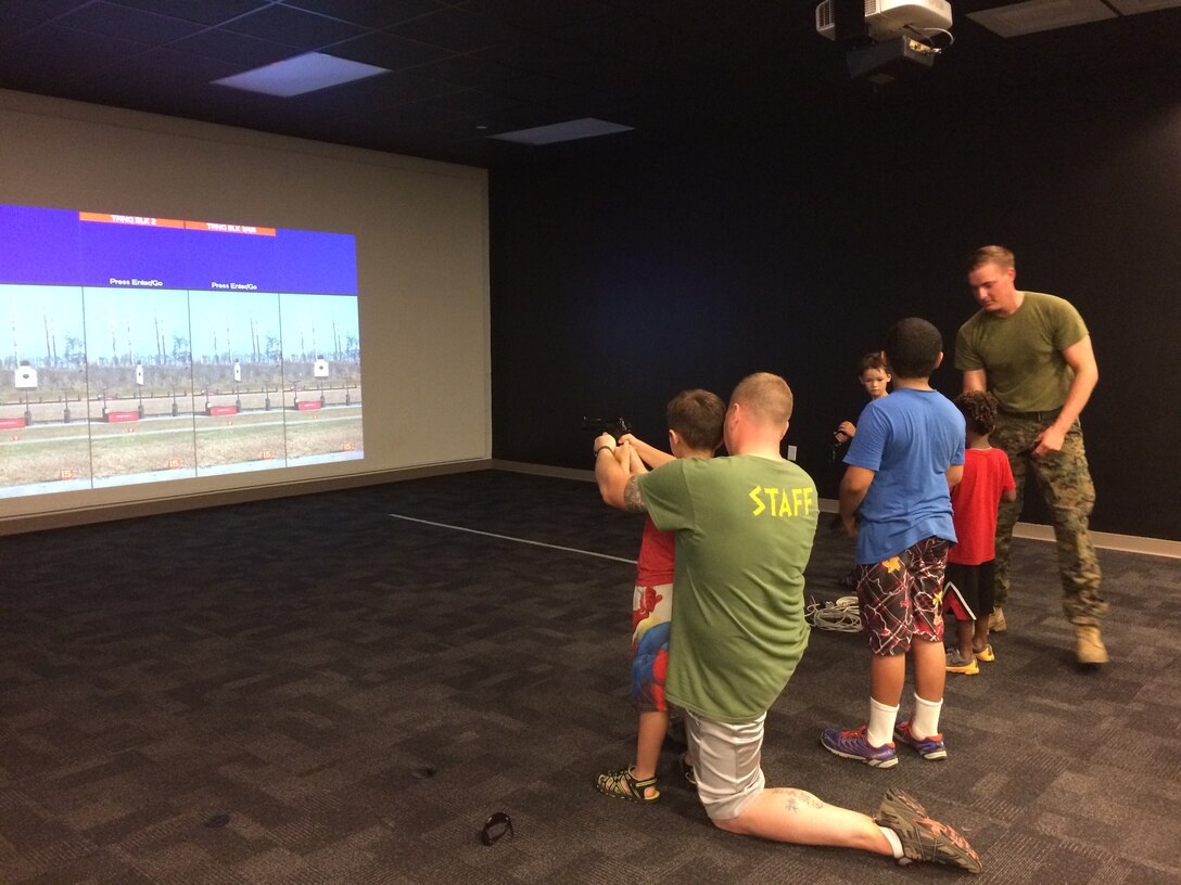 On 18 August, 2017 MCES held its annual Kids Rock Day. Throughout the day parents and children participated in engineer, utilities, and Marine themed activities which showcased their parents' contribution to MCES. Marines assist their children with the 9 mm pistol at 2d Combat Engineer Battalions Indoor Simulated Marksmanship Trainer (ISMT).