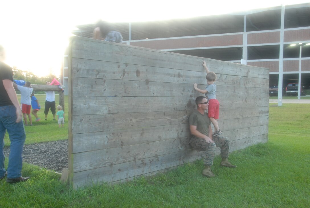 On 18 August, 2017 MCES held its annual Kids Rock Day. The first event of the day was a short fartlek run with a modified obstacle course. Staff Sergeant Beau Varner helps his son over the wall as part of the modified obstacle course.