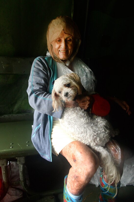 A woman sits with a dog on her lap.