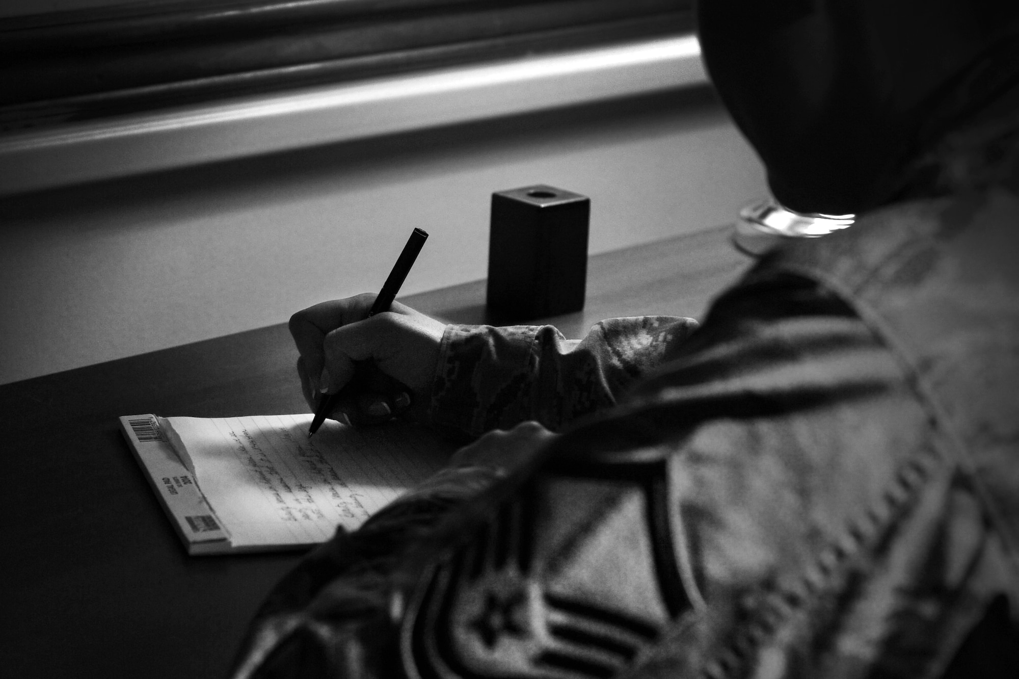A photo depiction of a master sergeant writing poems with pen and paper. Master Sgt. Zhyronn Carter, 373rd Intelligence, Surveillance and Reconnaissance Group/Alaska Mission Operations Center, Joint Base Elmendorf-Richardson, Alaska, recently published her book in November 2016. According to Carter, her book consists of poems about domestic abuse and sexual trauma from different points of views. (U.S. Air Force photo/Staff Sgt. Alexandre Montes)