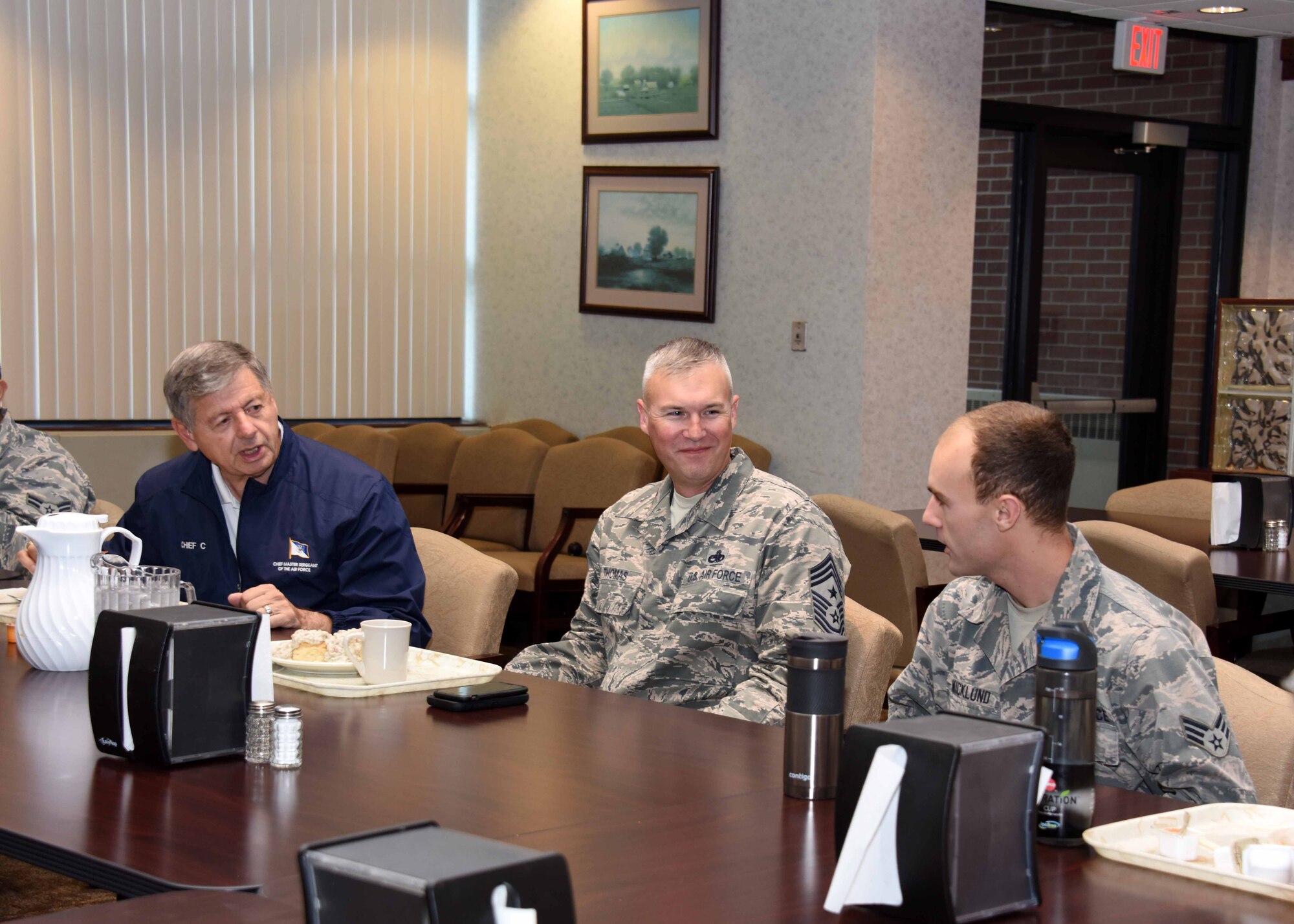 The 11th Chief Master Sergeant of the Air Force, retired, David J. Campanale, left, and CMSgt. Brian Thomas, 319th Air Base Wing command chief, answers a question asked by Senior Airman Mitchell Wicklund, 319th Logistics Readiness Squadron refueling maintenance technician, at the Airey Dining Facility August 25, 2017, on Grand Forks Air Force Base N.D. The chief toured various facilities throughout the installation during his visit here. (U.S. Air Force photo by Senior Airman Cierra Presentado)