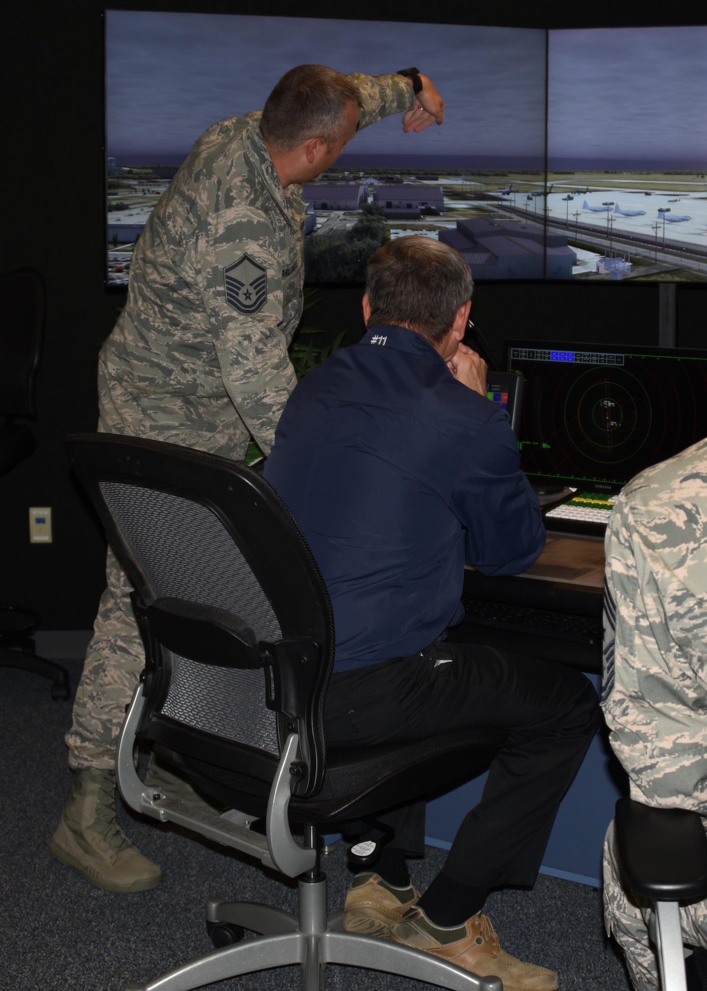 The 11th Chief Master Sergeant of the Air Force, retired, David J. Campanale, listens to a briefing given by Master Sgt. Timothy Carlsness, 319th Operations Support Squadron tower chief controller, during a visit to the base Aug. 25, 2017, at Grand Forks Air Force Base, N.D. Campanale spent the day visiting various work centers and later spoke at the Senior NCO induction ceremony as the guest speaker. (U.S. Air Force photo by Senior Airman Cierra Presentado.