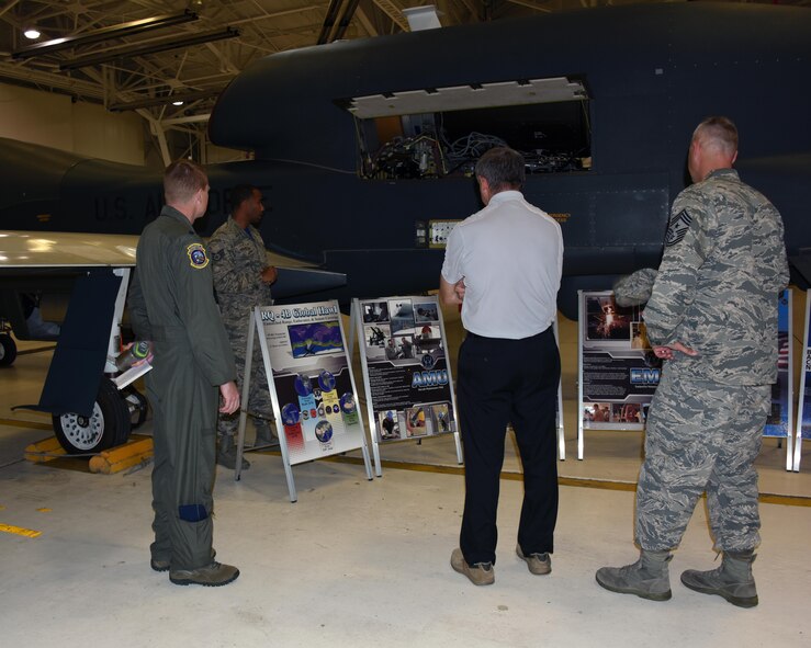 The 11th Chief Master Sergeant of the Air Force, retired, David J. Campanale, center, and Chief MSgt. Brian Thomas, 319th Air Base Wing command chief, right, is given a briefing on the RQ-4 Global Hawk by Lt. Col Kendall Gillespie, 348th Reconnaissance Squadron commander and Staff Sgt. Michael Newsome, 69th Maintenance Squadron aircraft maintainer, during a visit to the installation Aug. 25, 2017, at Grand Forks Air Force Base, N.D. Campanale spent the day visiting various work centers and later spoke at the Senior NCO induction ceremony as the guest speaker. (U.S. Air Force photo by Senior Airman Cierra Presentado)