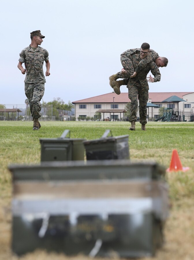 Cpl. Joseph Cherie, an ordnance specialist with Headquarters and Headquarters Squadron (H&HS), fireman carries Lance Cpl. Dalton Oertli during the maneuver under fire portion of the Warrior Challenge at Marine Corps Air Station Miramar, Calif., Aug 22.  This monthly challenge gives sections within H&HS the opportunity to work as a team and compete in several training events. (U.S. Marine Corps photo by Cpl. Andrianna Talbot/Released)