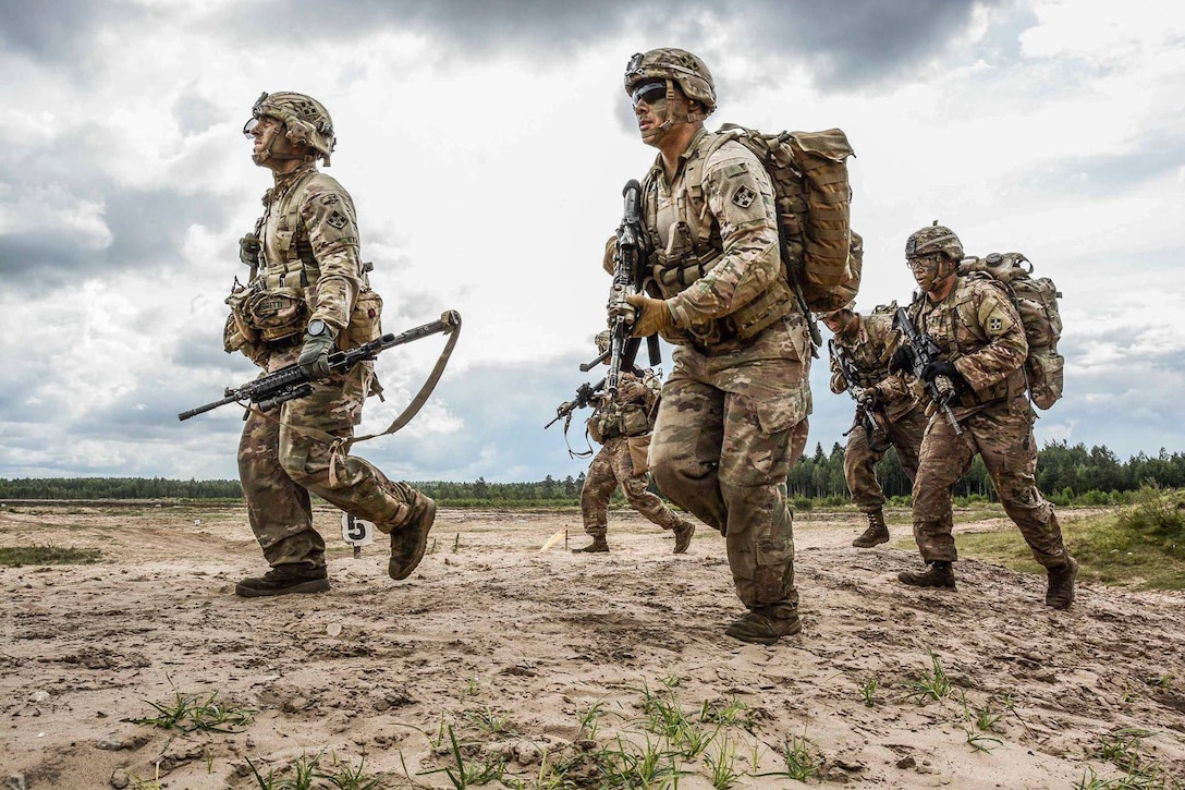 A group of soldiers walks together carrying weapons.