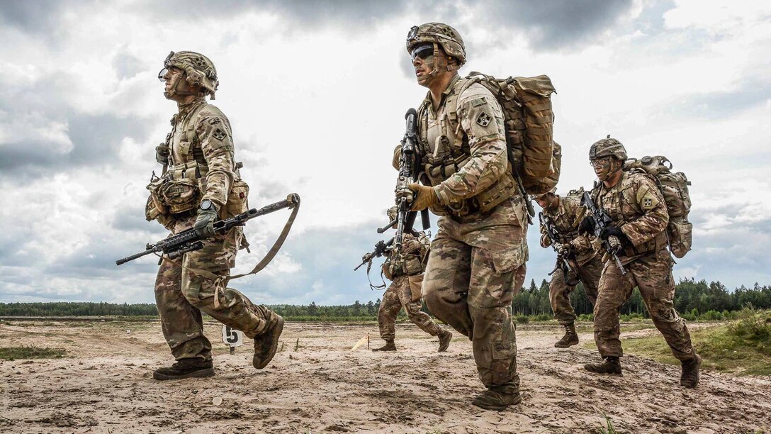 A group of soldiers walks together carrying weapons.