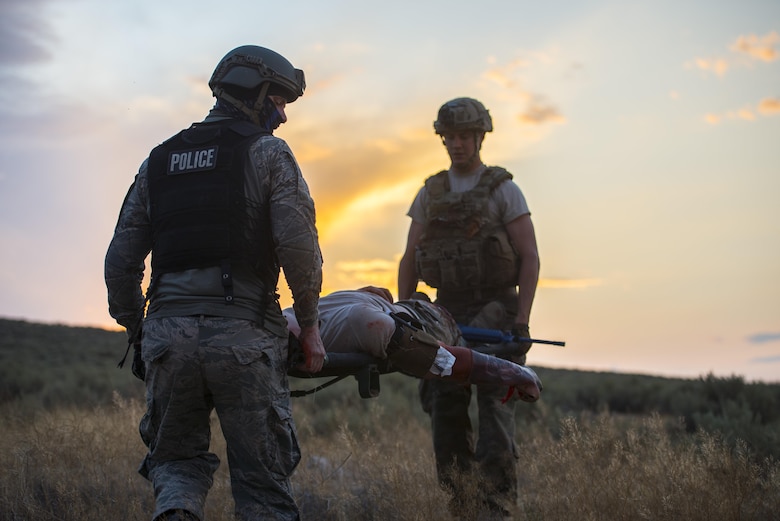 Camerin Hillman, department of the Air Force training instructor and Senior Airman Kelly Kroll, 366th Civil Engineer Squadron explosive ordinance disposal technician transport an injured party during an exercise August 24, 2017, at Orchard training area, Idaho. Civilian contractors and members of the 366th Medical Group attended the exercise and used their experience to improve future training. (U.S. Air Force photo by Airman 1st Class Jeremy D. Wolff/Released)