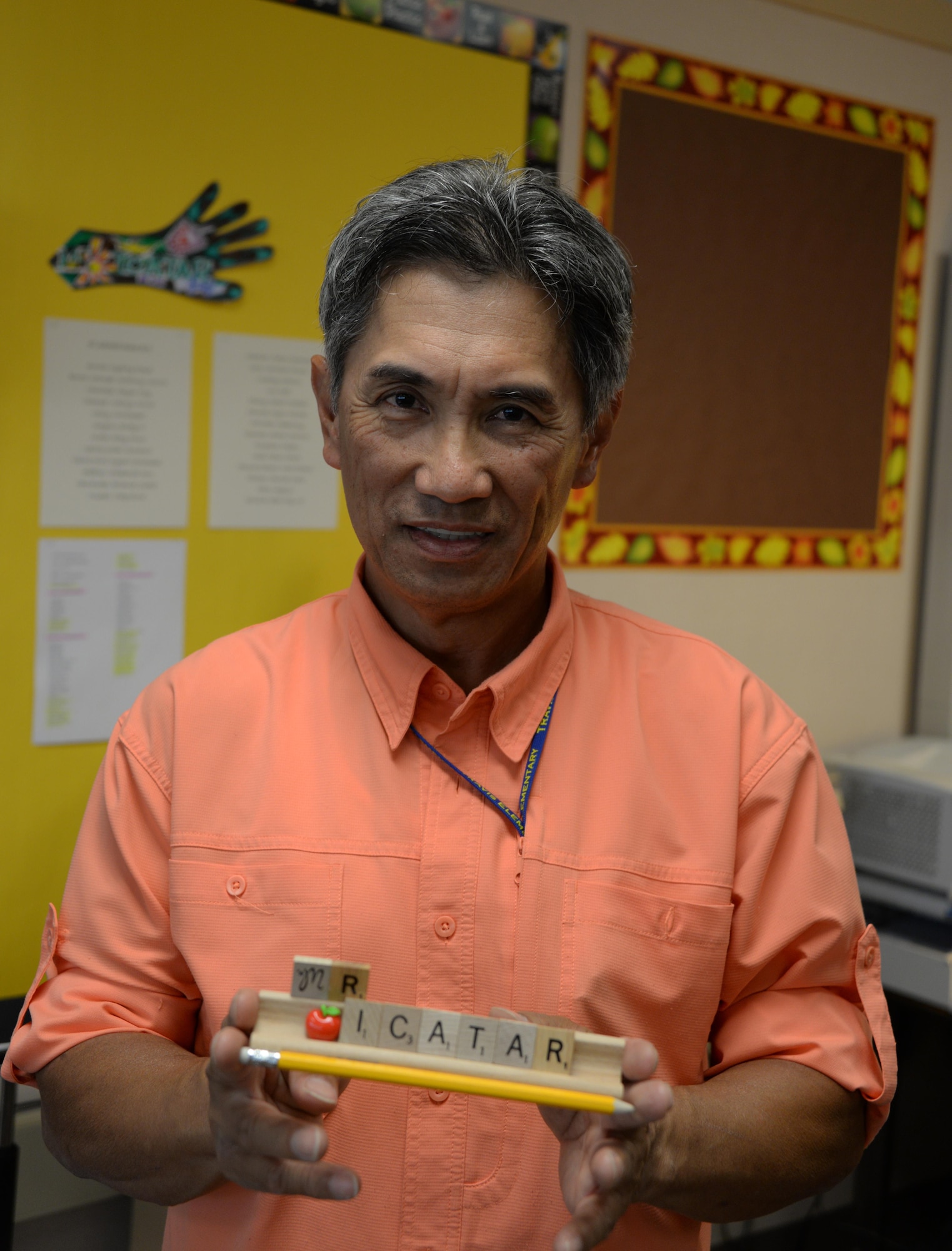Nonato Icatar, a retired U.S. Air Force technical sergeant and a teacher at Travis Elementary School, poses for a photo while holding a name plate made from Scrabble tiles that was given to him by one of his students at Travis Air Force Base, Calif., Aug. 25. Icatar served as an Airman Leadership School professional military education instructor and a training manager during his 20-year Air Force career. At Travis Elementary School he teaches math, English language arts, science and history to 5th grade students. (U.S. Air Force photo by Tech. Sgt. James Hodgman)