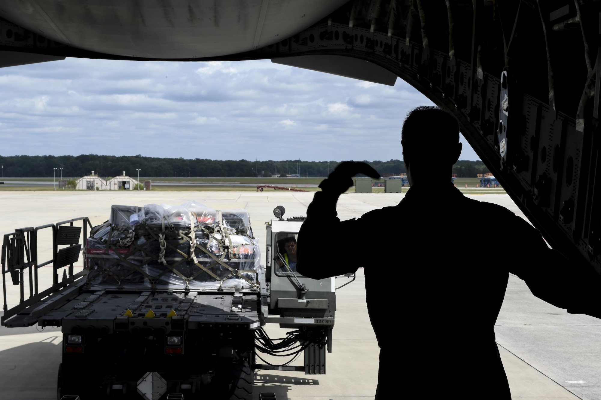 Tech Sgt. Joe Joiner, 16th Airlift Squadron loadmaster, guides a member of the 78th Logistics Readiness Squadron, Robins Air Force Base, Ga., as they load a cargo pallet on to the C-17 Globemaster III at the Robins AFB Aug. 29.