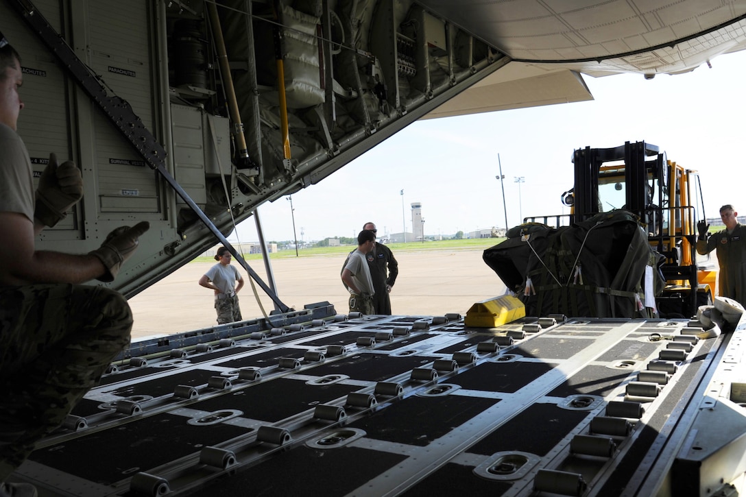 Airmen load equipment onto an aircraft.