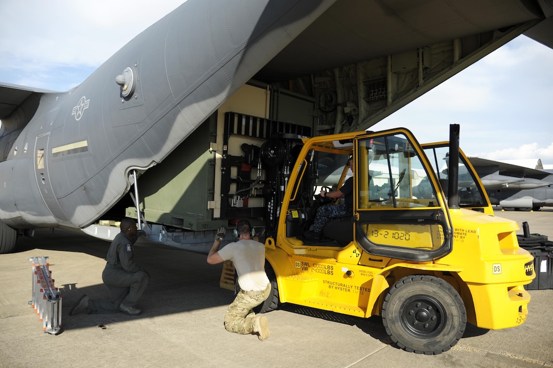 Airmen load supplies onto an aircraft.
