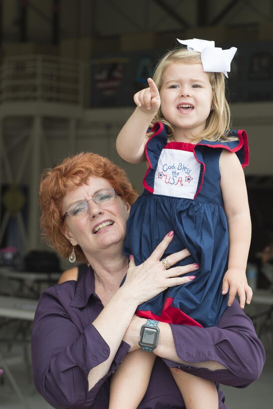 Jill Marconi-Pyclik, 434th Force Support Squadron Airman and Family Readiness director, holds Palmer Wright, 3, as she points to a returning aircraft at Grissom Air Reserve Base, Ind. Aug. 22, 2017. The aircraft was returning her father, Senior Airman Brian Wright, 434th Maintenance Squadron aerospace ground equipment specialist, following a deployment to Turkey.  (U.S. Air Force photo/Tech. Sgt. Benjamin Mota)