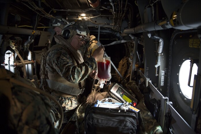 A corpsman inspects a blood bag for a simulated casualty during an en-route care training exercise for 2nd Medical Battalion at Camp Lejeune, N.C. on Aug 24, 2017.