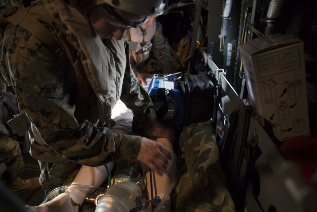 A corpsman inspects a splint on a simulated casualty during an en-route care training exercise for 2nd Medical Battalion at Camp Lejeune, N.C. on Aug 24, 2017. The training was conducted to prepare corpsmen to successfully aid casualties while transporting them via aircraft to a higher level of medical attention. The sailors are with 2nd Medical Battalion. (U.S. Marine Corps photo by Pvt. Nicholas Guevara)