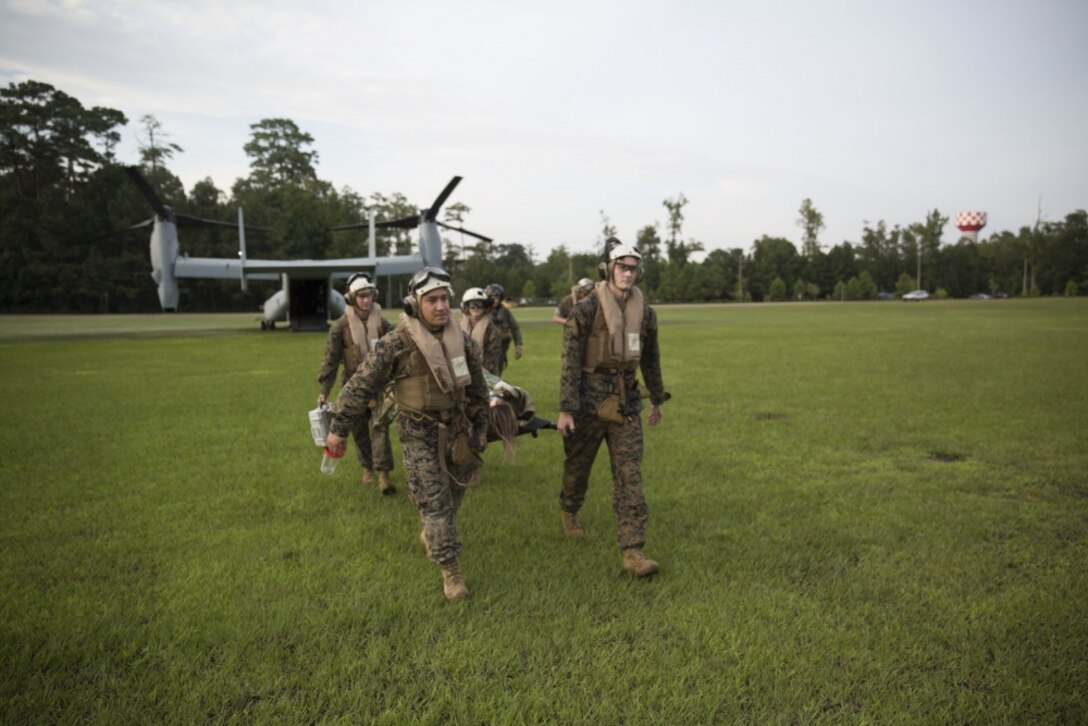 Corpsmen carry a simulated casualty off of an MV-22 Osprey toward an ambulance during an en-route care training exercise for 2nd Medical Battalion at Camp Lejeune, N.C. on Aug 24, 2017. The training was conducted to prepare corpsmen to successfully aid casualties while transporting them via aircraft to a higher level of medical attention. The sailors are with 2nd Medical Battalion. (U.S. Marine Corps photo by Pvt. Nicholas Guevara)